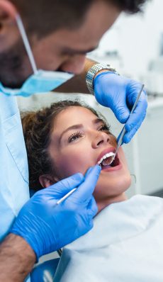 Beautiful young woman having dental treatment at dentist's office.